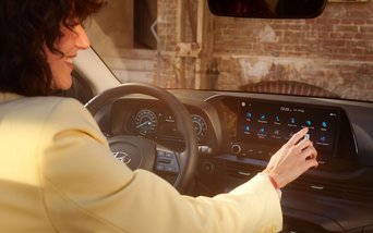 Fahrerin bedient modernes Hyundai Infotainmentsystem im Innenraum – Symbolbild für die Abverkaufsaktion von Hyundai i20 und BAYON bei S&G.